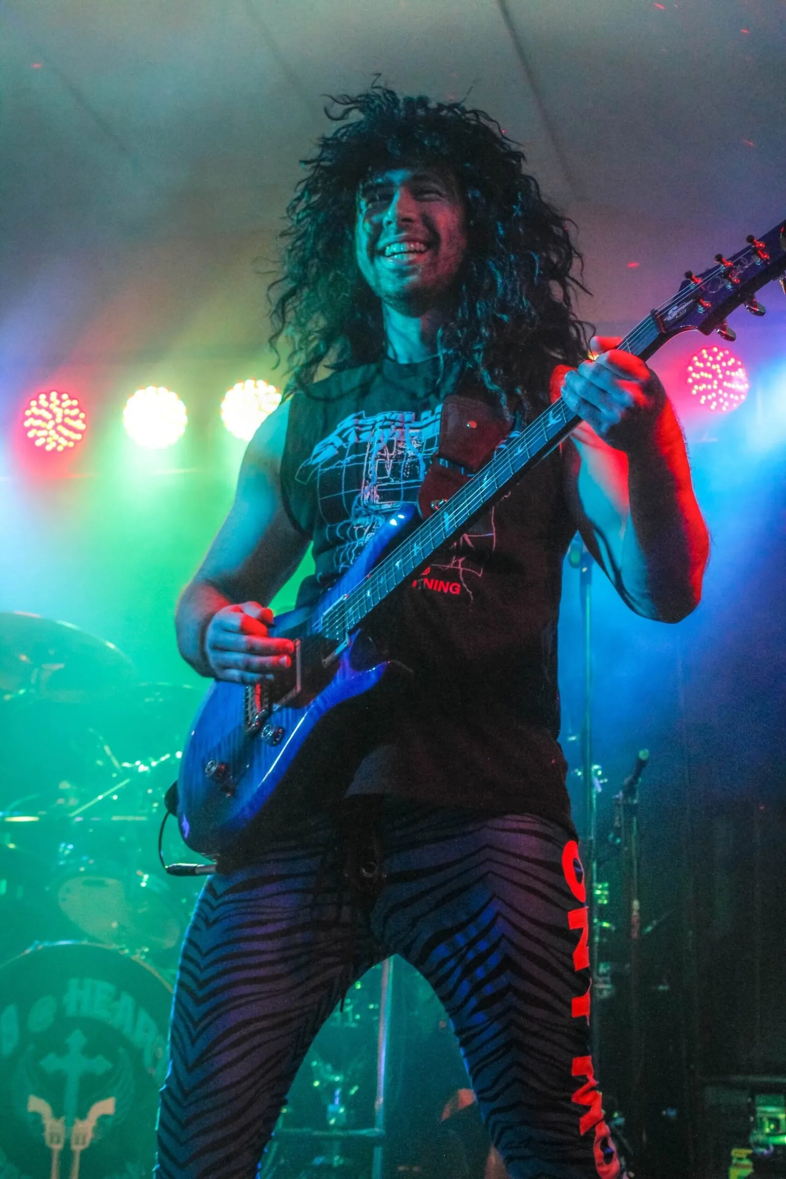 Guitarist mid-solo in green stage light